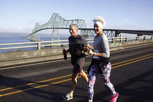 Man & woman running in Great Columbia Crossing Race over Astoria-Megler Bridge