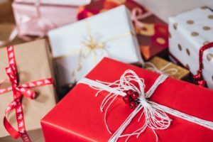 pile of holiday gift packages wrapped in red white and brown paper with ribbons